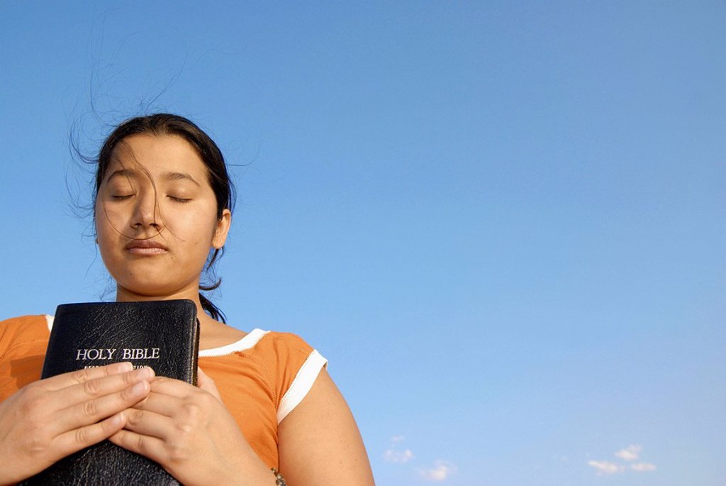 LATINO WOMAN HOLDING BIBLE.