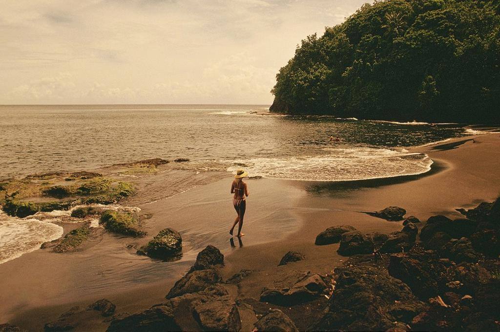 A WOMAN RUNNING ON A TROPICAL ISLAND BEACH