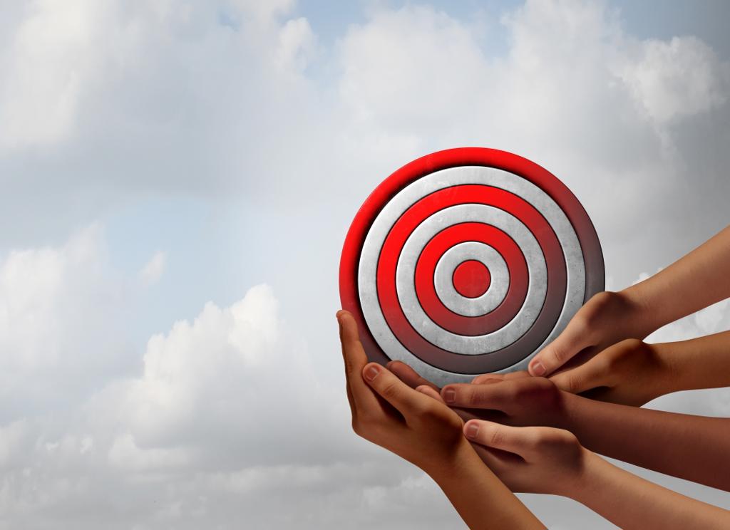 TARGET AUDIENCE CONCEPT AS A GROUP OF DIVERSE HANDS HOLDING A BULLSEYE AS A BUSINESS MARKETING METAPHOR FOR CUSTOMER AND CONSUMER FOCUS GROUP TARGETING