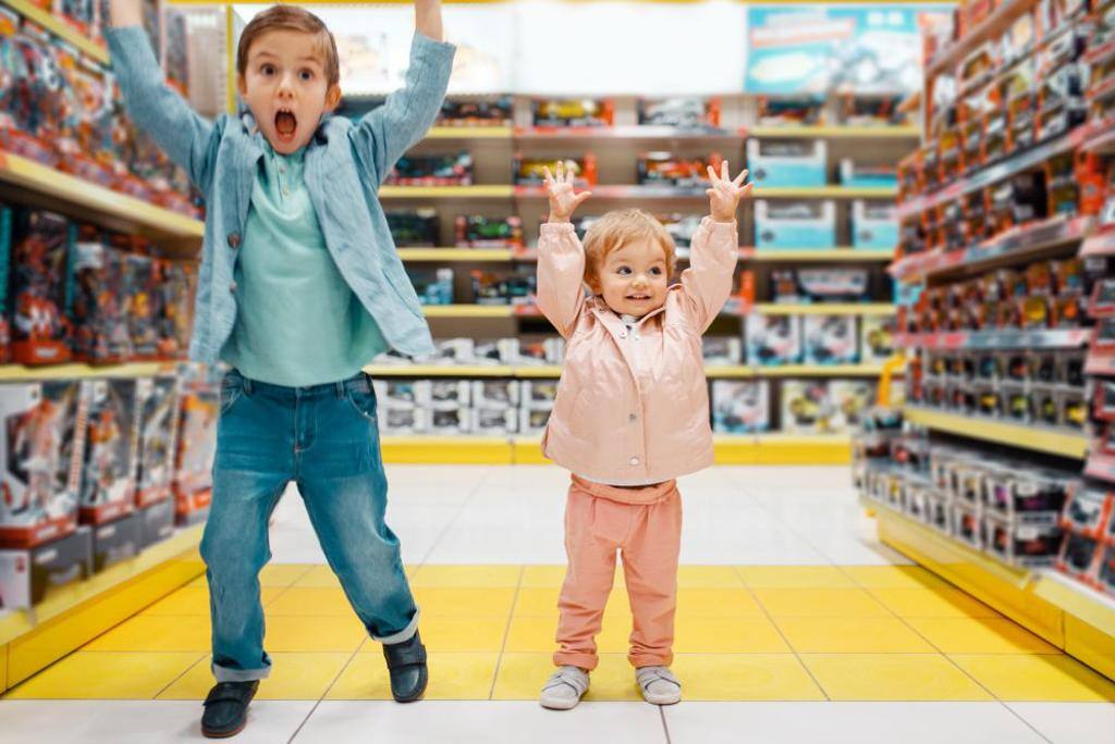 Brother and sister choosing toys in supermarket