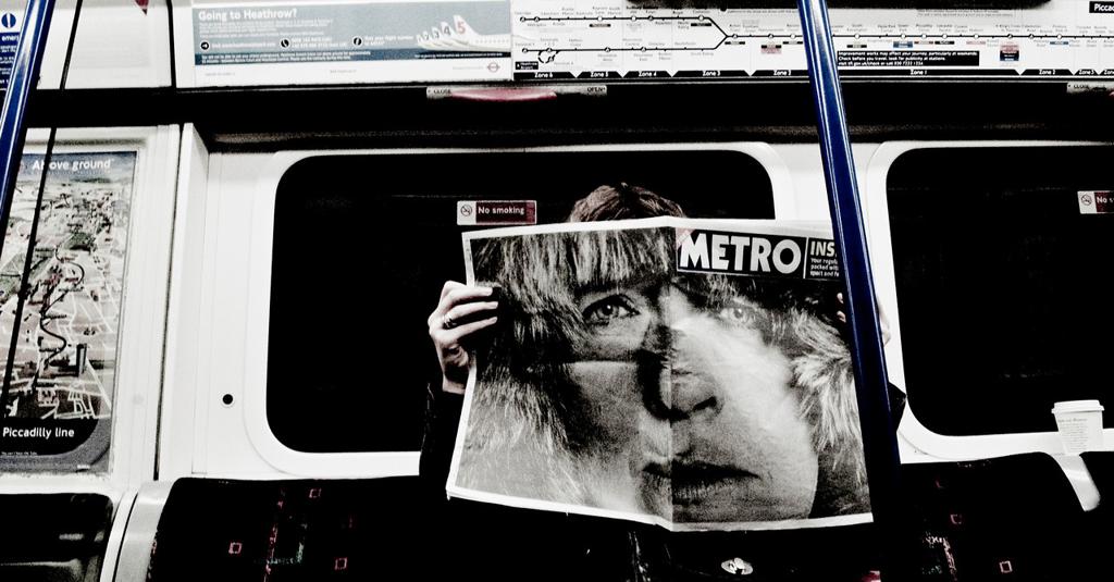 READING THE NEWSPAPER INSIDE A SUBWAY CAR