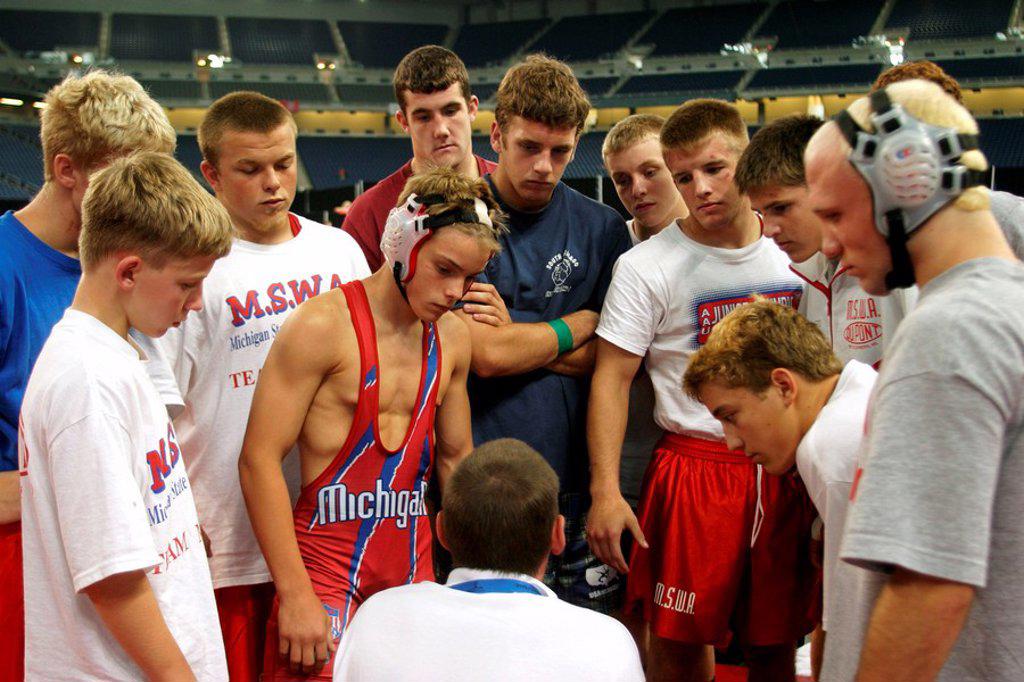 THE AAU JUNIOR OLYMPICS A COACH GATHERS HIS TEAM FOR A PEP TALK BEFORE WRESTLING COMPETITION