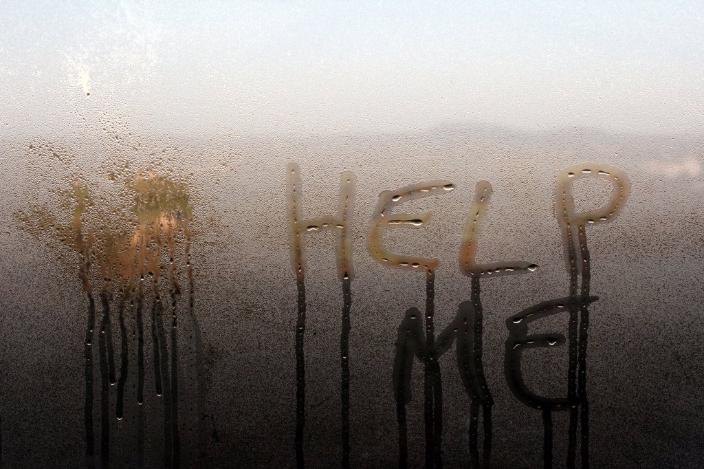 HELP ME WORDS WRITTEN ON WINDOW WITH CONDENSATION IN HOUSE IN COUNTRYSIDE