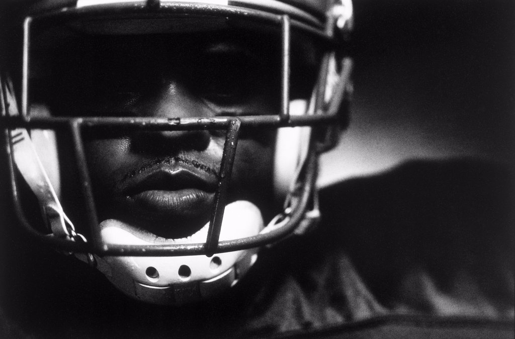 CLOSE-UP OF AN AMERICAN FOOTBALL PLAYER WEARING A HELMET