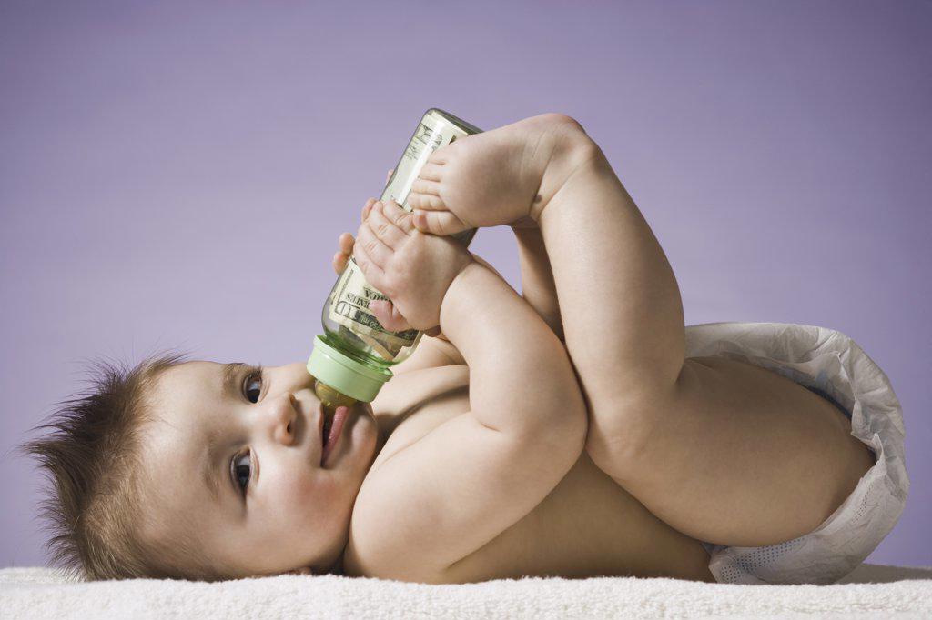 BABY DRINKING FROM BOTTLE WITH US CURRENCY IN IT