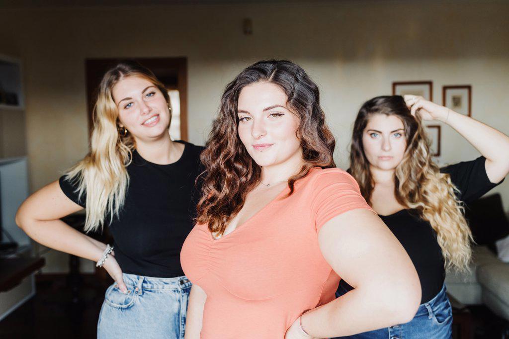 PORTRAIT OF THREE CONFIDENT YOUNG WOMEN AT HOME