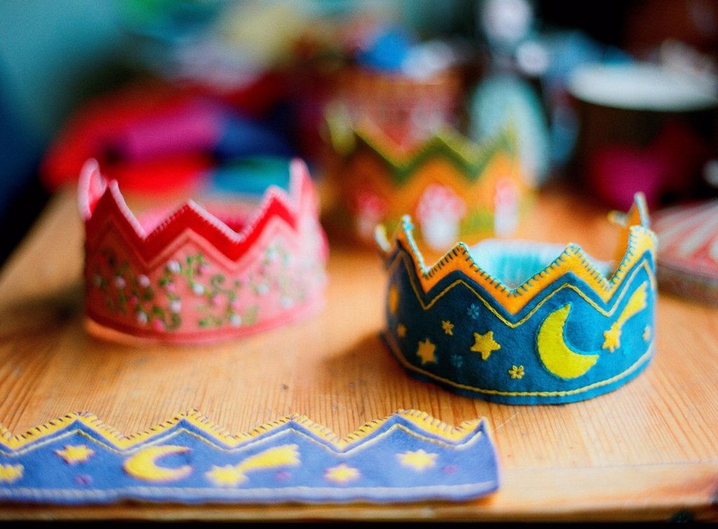 VIEW OF TWO HANDMADE CROWNS ON TABLE MADE FOR CHILD'S BIRTHDAY