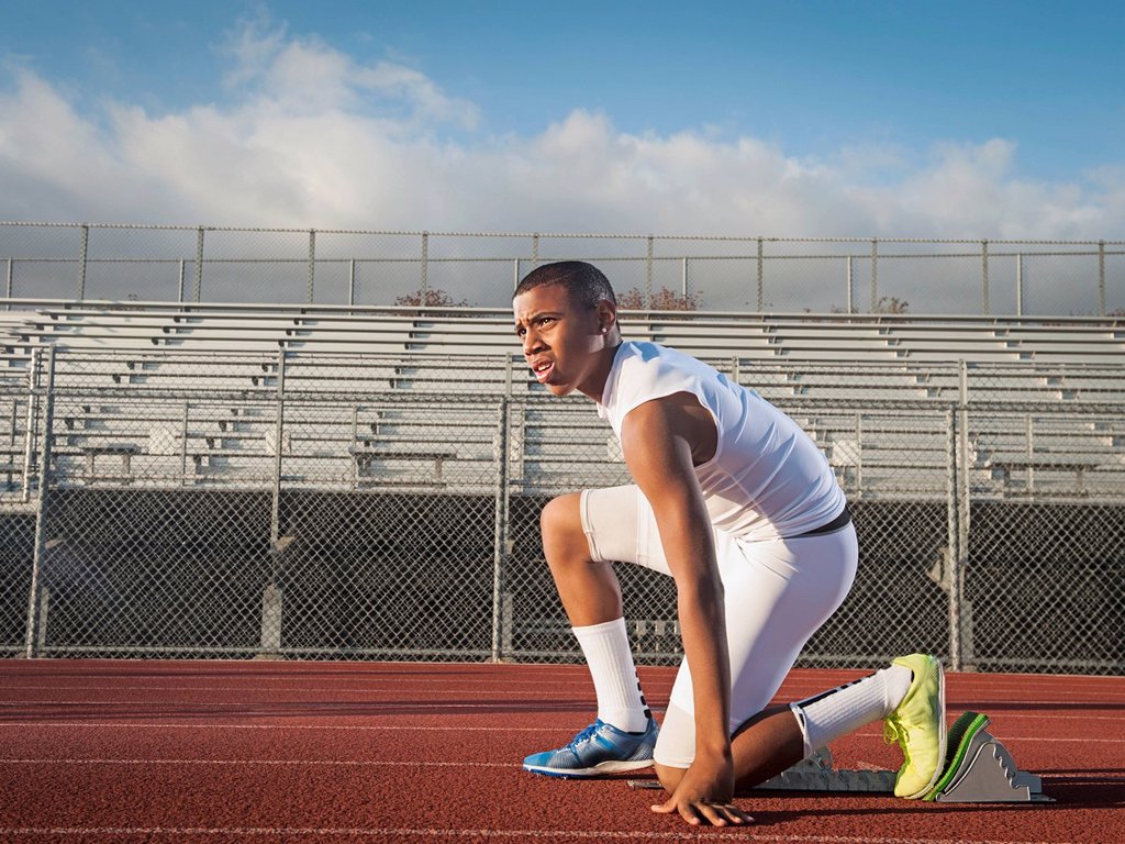 BOY PREPARING FOR RUNNING ON STARTING LINE