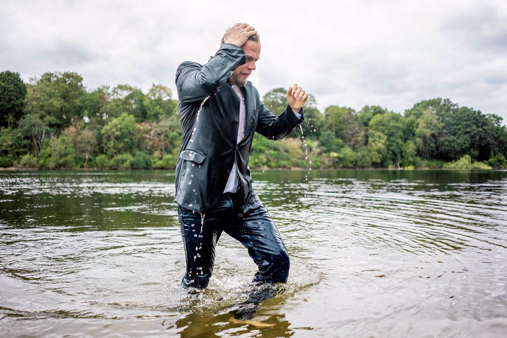 WET BUSINESSMAN WALKING IN A LAKE