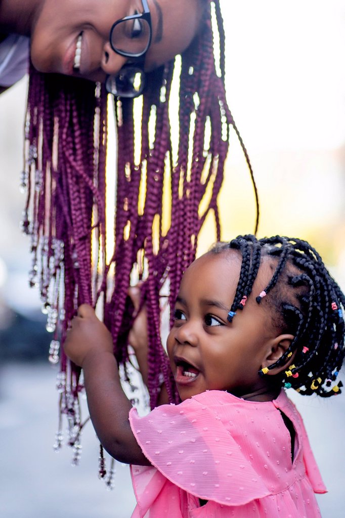 GIRL PLAYING WITH MOTHER'S HAIR