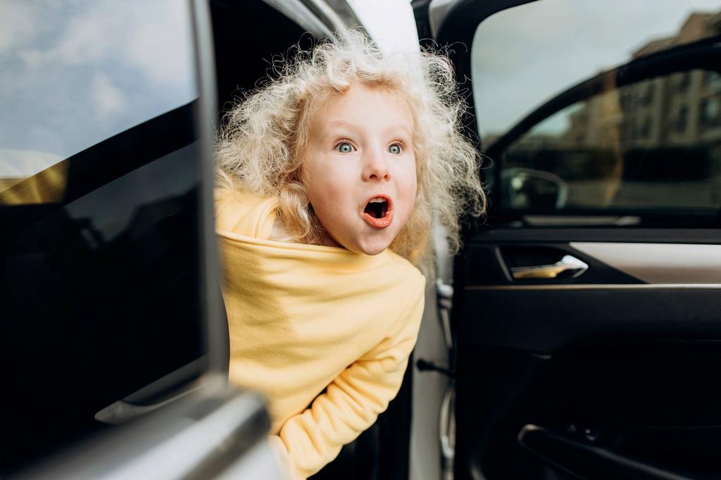 EXCITED GIRL LEANING OUT OF CAR