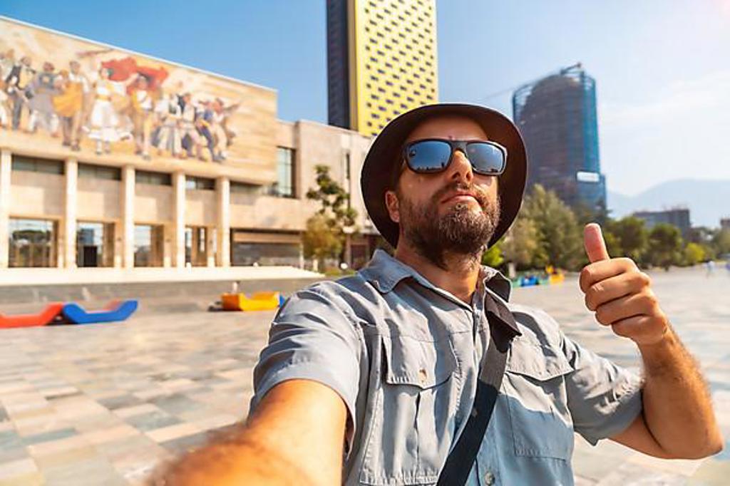 SELFIE OF A TOURIST BLOGGER AT THE ENTRANCE TO THE NATIONAL HISTORICAL MUSEUM IN SKANDERBEG SQUARE IN TIRANA