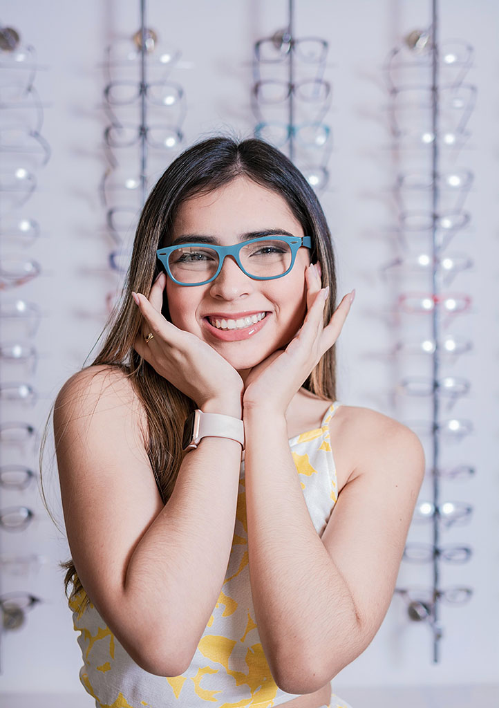 Portrait of a happy female customer wearing glasses in an eyewear store