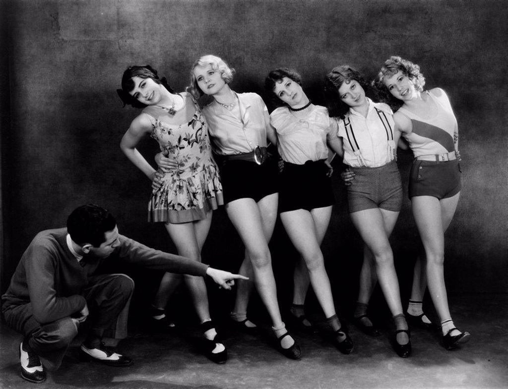 DANCE INSTRUCTOR INSTRUCTING FIVE YOUNG WOMEN 