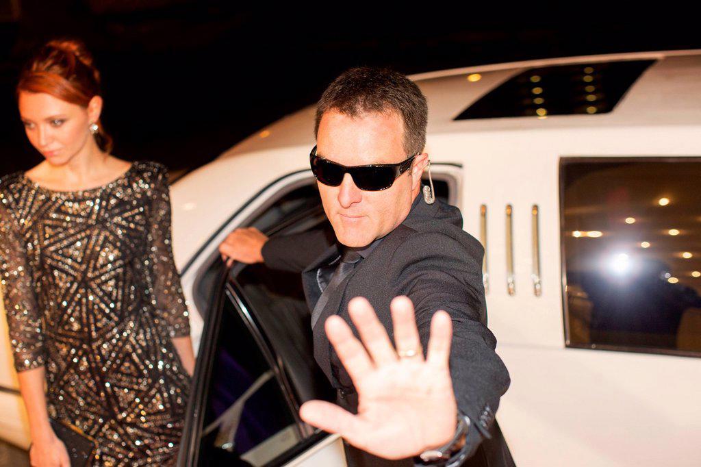 BODYGUARD PROTECTING CELEBRITY FROM PAPARAZZI OUTSIDE LIMOUSINE