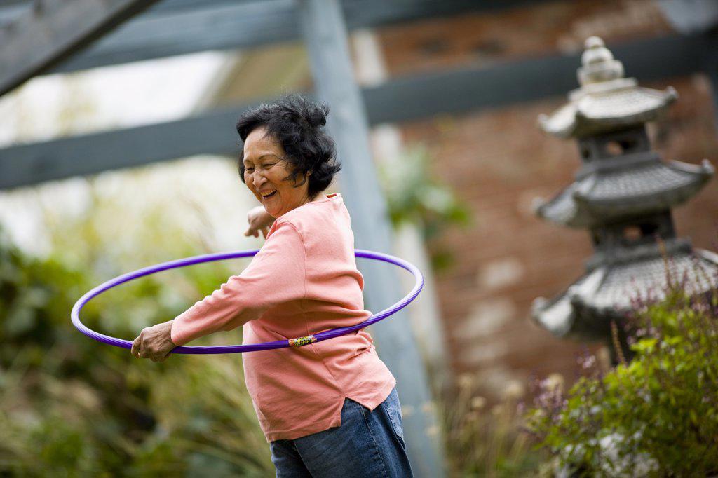 OLDER WOMAN PLAYING WITH HULA HOOP