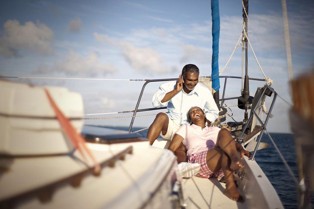 MATURE COUPLE RELAXING TOGETHER ON BOAT DECK IN THE SUNSHINE.