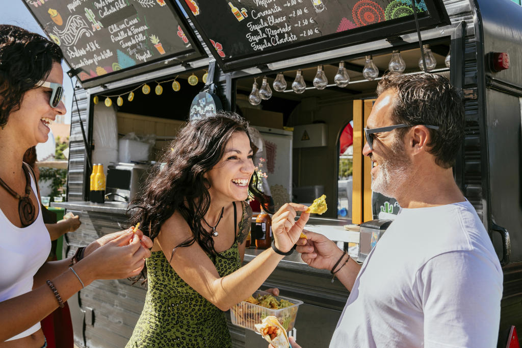 PEOPLE EATING SNACKS AT FOOD TRUCK