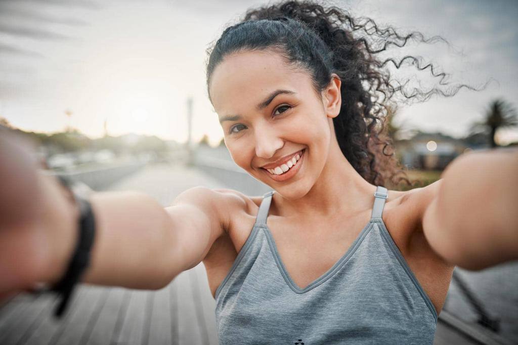 Cropped portrait of an attractive young female athlete taking selfies during her morning run outside