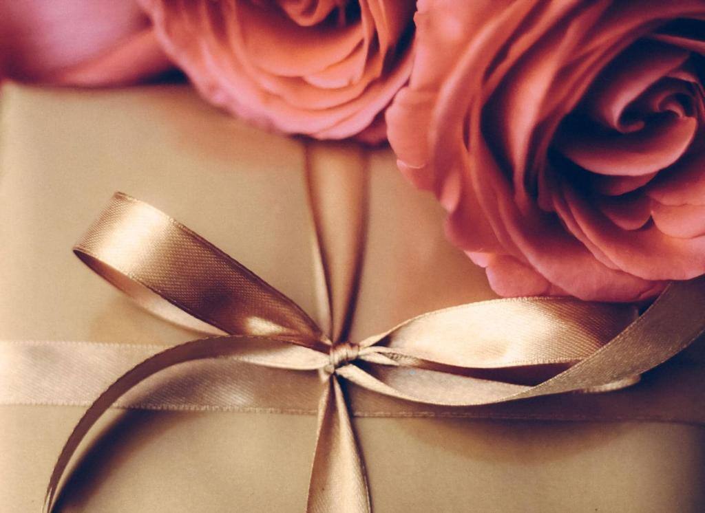 Luxury holiday golden gift box and bouquet of roses as Christmas, Valentines Day or birthday present