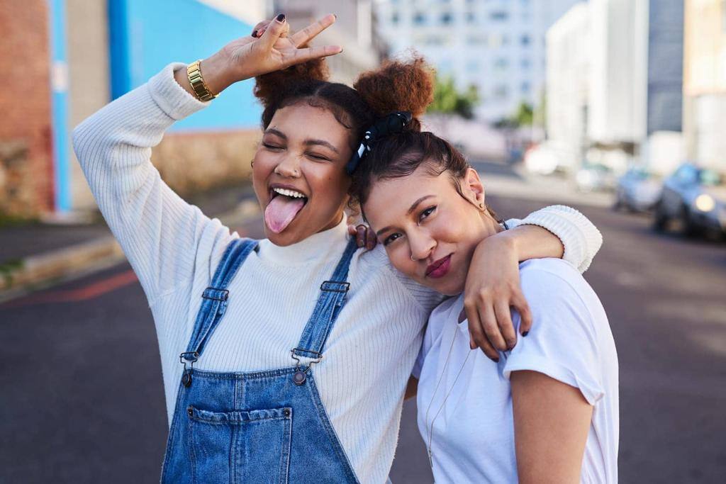 Were off to that white and denim party. two young woman out in the city during the day.