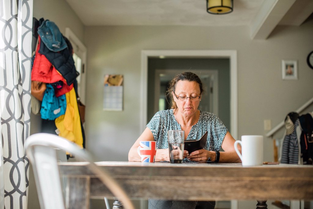 MIDDLE AGED WOMAN LOOKING ON HER SMART PHONE AND HAVING COFFEE