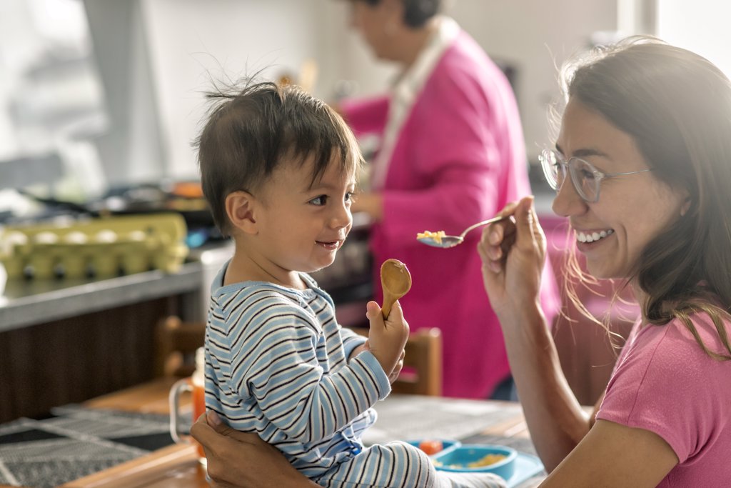 CUTE LATIN MOM SHARING SMILES WITH HER SON AT BREAKFAST